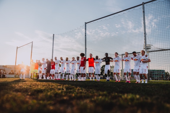 Fußballspieler des FC Red Bull Salzburg stehen in einer Reihe auf dem Rasen.