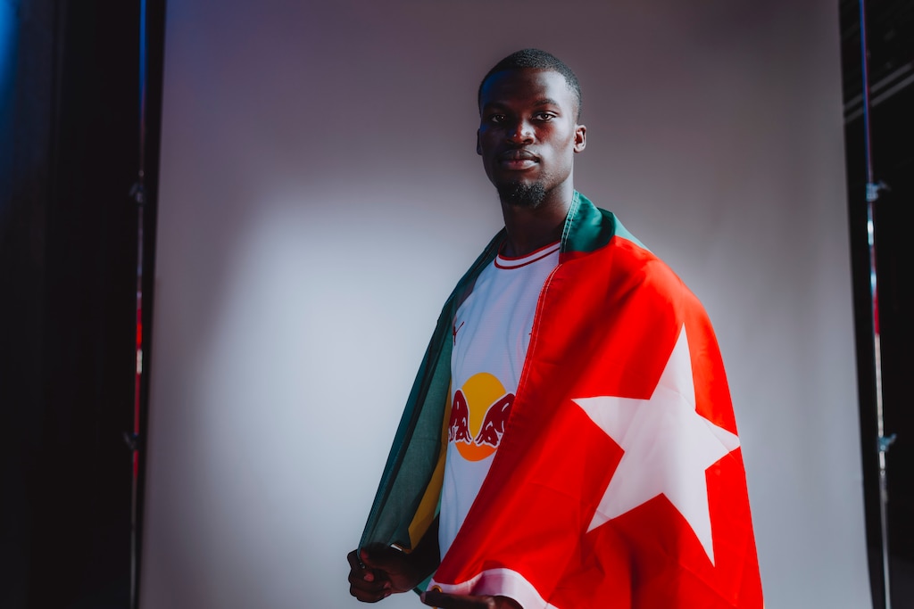 Fußballer mit togolesischer Flagge vor grauem Hintergrund