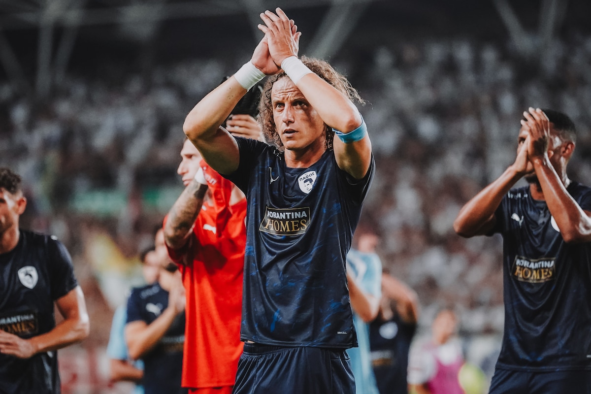 Fußballer mit lockigem Haar klatscht im Stadion vor jubelndem Publikum in Limassol.